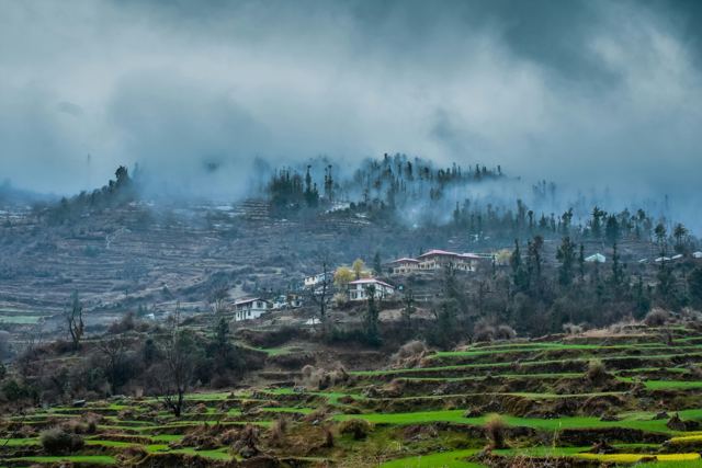 Hill village and green terraced fields under low cloud